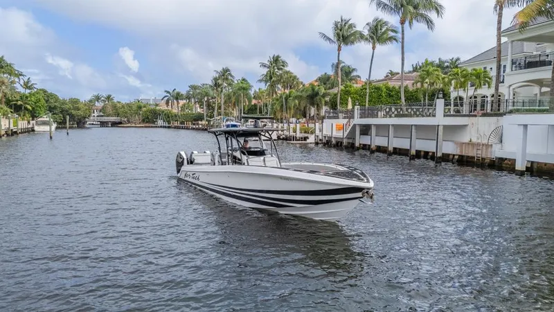 Slide: The Image of 2024 Nor-Tech 392 Super Fish boat cruising on a scenic waterway with palm trees. - 10