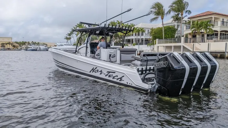 Slide: The Image of 2024 Nor-Tech 392 Super Fish boat with multiple engines on a calm waterway. - 11