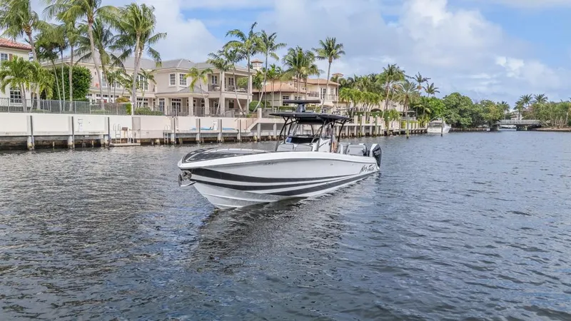 Slide: The Image of 2024 Nor-Tech 392 Super Fish boat cruising on a scenic waterway with palm trees. - 12