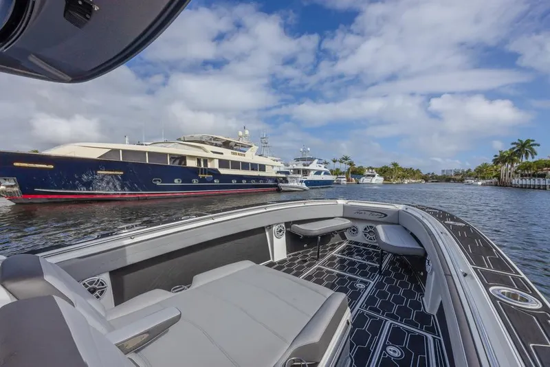 Slide: The Image of 2024 Nor-Tech 392 Super Fish boat interior with luxury yachts in marina background. - 13