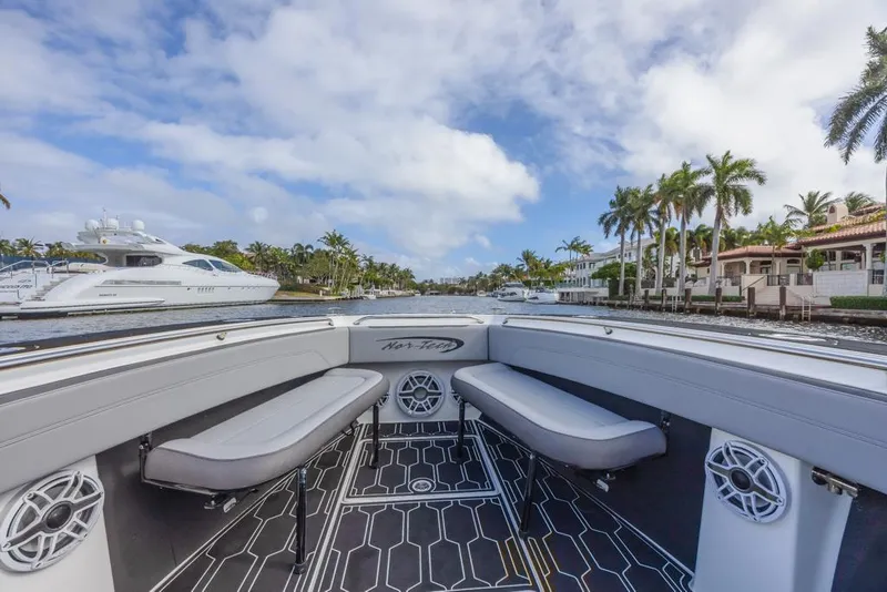 Slide: The Image of 2024 Nor-Tech 392 Super Fish boat interior with seating, speakers, and scenic waterfront view. - 14