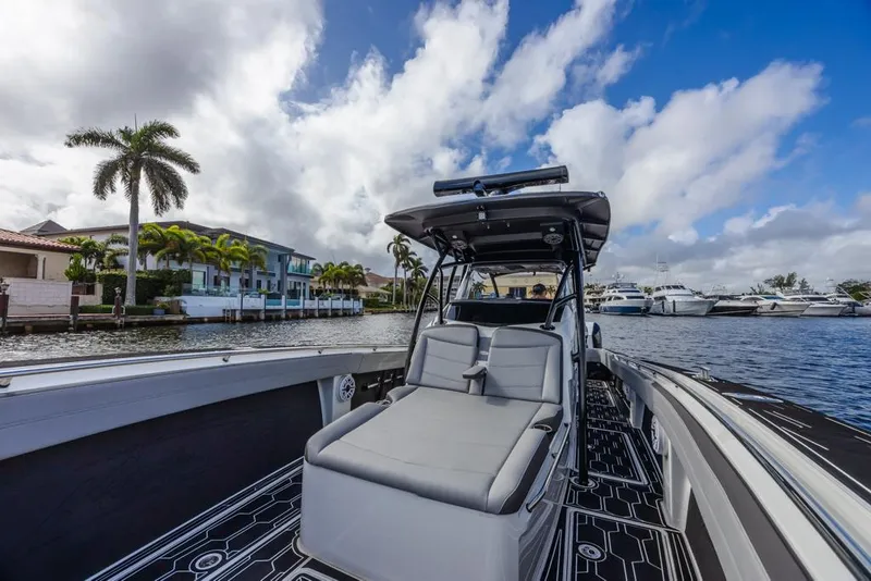 Slide: The Image of 2024 Nor-Tech 392 Super Fish boat on a scenic waterfront with palm trees and yachts. - 18