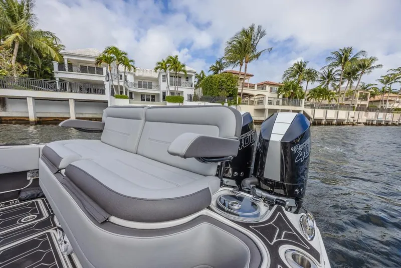 Slide: The Image of 2024 Nor-Tech 392 Super Fish boat with luxurious seating and powerful engines on a scenic waterfront. - 27