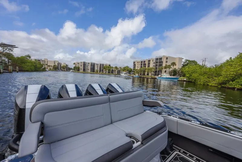 Slide: The Image of 2024 Nor-Tech 392 Super Fish boat on a scenic waterway with modern buildings. - 28