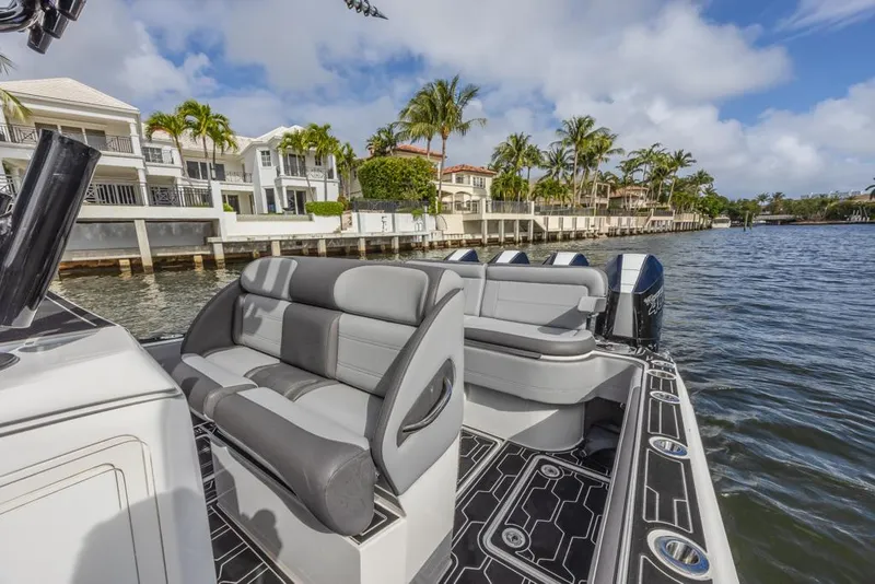 Slide: The Image of 2024 Nor-Tech 392 Super Fish boat with luxurious seating, docked near waterfront homes. - 30
