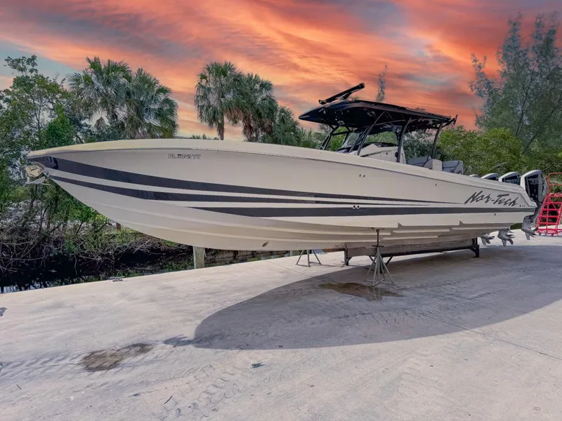 Slide: The Image of 2024 Nor-Tech 392 Super Fish boat on a dock at sunset, surrounded by trees. - 5