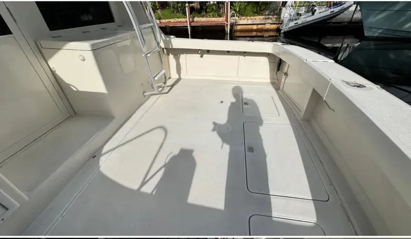 Slide: The Image of 1987 Blackfin Convertible boat deck, spacious and clean, with visible ladder and shadow. - 10