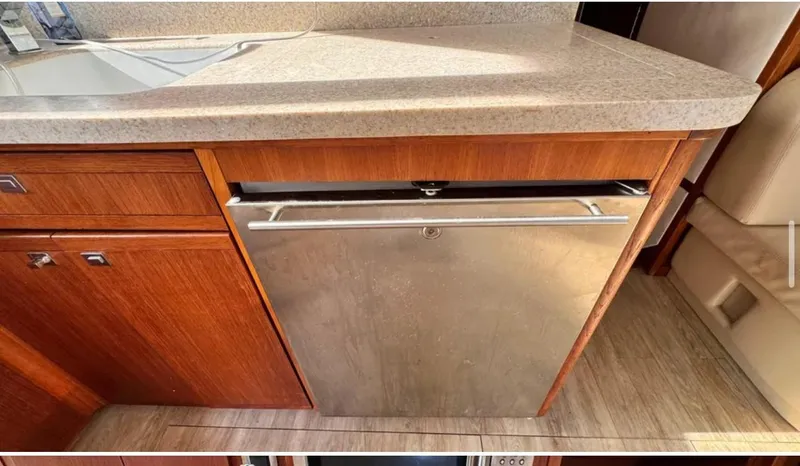 Slide: The Image of 1987 Blackfin Convertible yacht kitchen with stainless steel dishwasher and wooden cabinetry. - 27