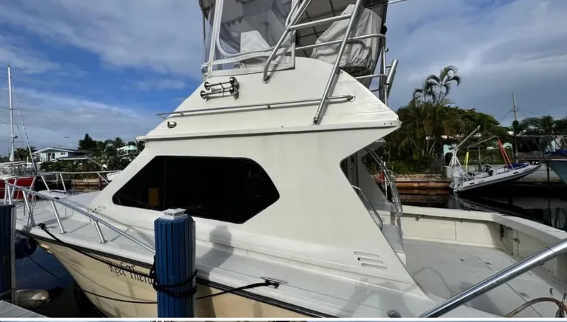Slide: The Image of 1987 Blackfin Convertible boat docked at marina, featuring sleek design and upper deck. - 3