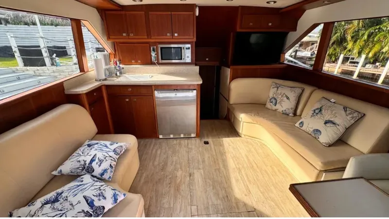 Slide: The Image of 1987 Blackfin Convertible yacht interior with beige seating, wooden cabinetry, and nautical-themed pillows. - 30
