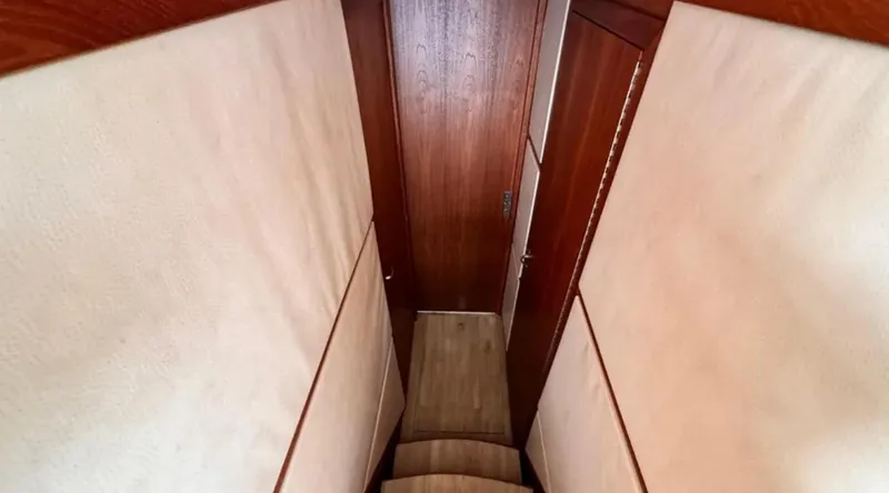 Slide: The Image of Interior stairs of a 1987 Blackfin Convertible boat with wooden paneling. - 35