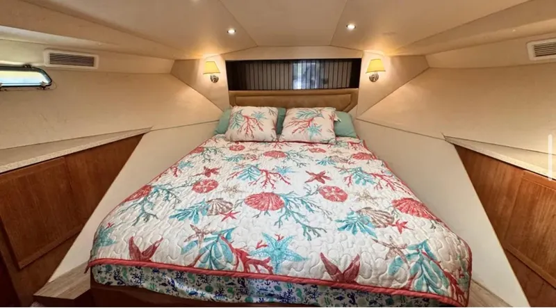 Slide: The Image of 1987 Blackfin Convertible cabin with a cozy bed and nautical-themed bedding. - 36
