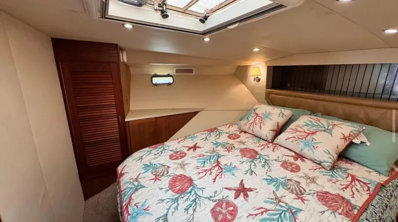 Slide: The Image of 1987 Blackfin Convertible cabin with nautical-themed bedding and cozy interior lighting. - 37