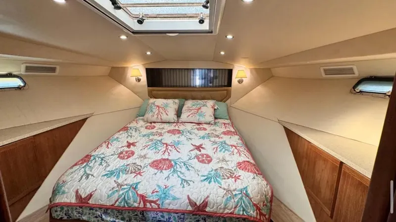 Slide: The Image of 1987 Blackfin Convertible cabin with a cozy bed and nautical-themed bedding. - 38