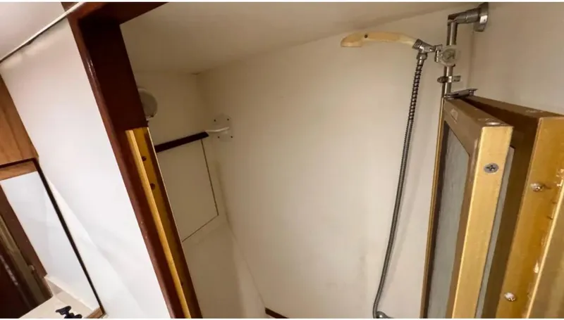 Slide: The Image of 1987 Blackfin Convertible boat shower area with handheld showerhead and glass door. - 43