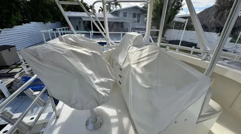 Slide: The Image of 1987 Blackfin Convertible boat with covered seats on the deck, surrounded by a residential area. - 45