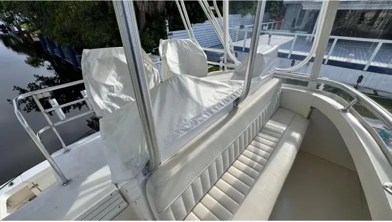 Slide: The Image of 1987 Blackfin Convertible boat interior with white seating and covered helm, docked by a canal. - 46