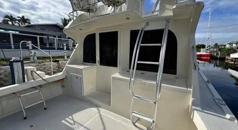 Slide: The Image of 1987 Blackfin Convertible boat with ladder and deck, docked near waterfront homes. - 9