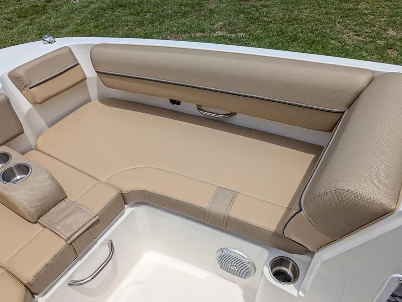 Slide: The Image of 2024 Bayliner DX2000 boat interior with beige seating and cup holders. - 10