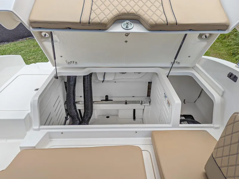 Slide: The Image of 2024 Bayliner DX2000 boat storage compartment with beige cushioned seating. - 11