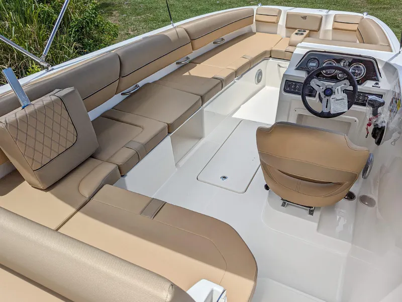 Slide: The Image of 2024 Bayliner DX2000 boat interior with tan seating and modern dashboard. - 2