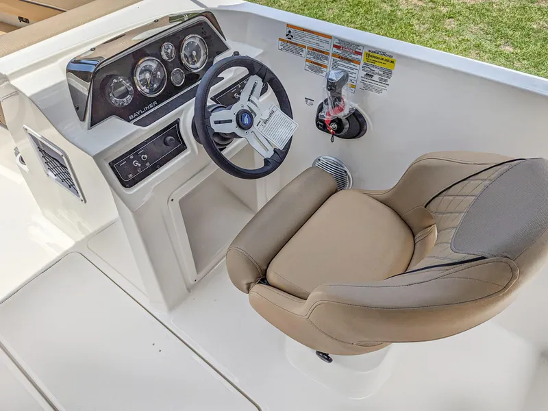 Slide: The Image of 2024 Bayliner DX2000 boat cockpit with steering wheel and comfortable seating. - 8