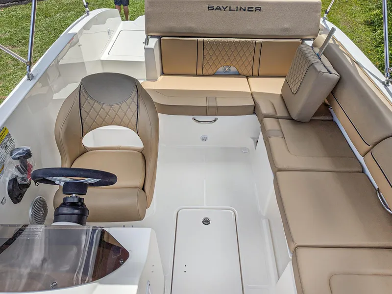Slide: The Image of 2024 Bayliner DX2000 boat interior with tan seating and steering wheel. - 9