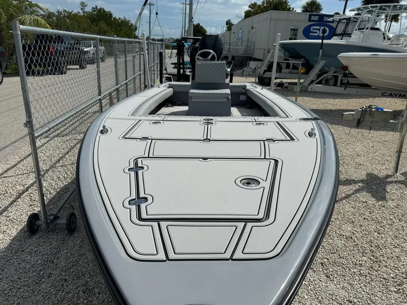 Slide: The Image of Custom Key Hopper 20 boat, 2023 model, docked on gravel, with sleek design and spacious deck. - 3