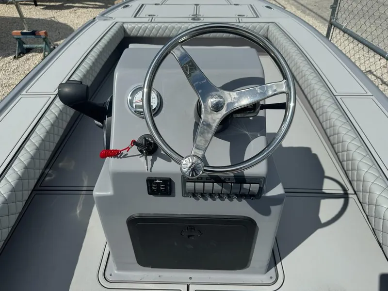 Slide: The Image of Steering console of 2023 Custom Key Hopper 20 boat with modern controls and sleek design. - 8