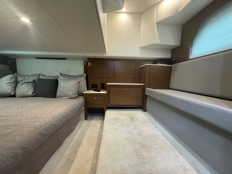 Slide: The Image of 2020 Cruisers Yachts 39 Express Coupe interior with bed, seating, and wooden cabinetry. - 40