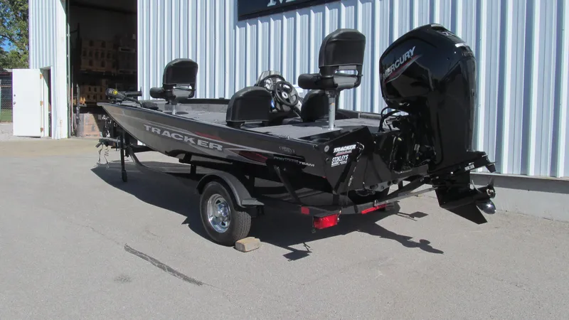 Slide: The Image of 2024 Tracker Pro Team 175 TF boat with Mercury engine, parked outside a building. - 3
