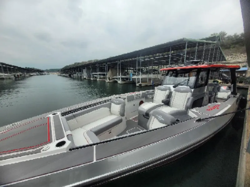 Slide: The Image of 2024 Fountain 38 SCX boat docked at marina, featuring sleek design and spacious seating. - 25