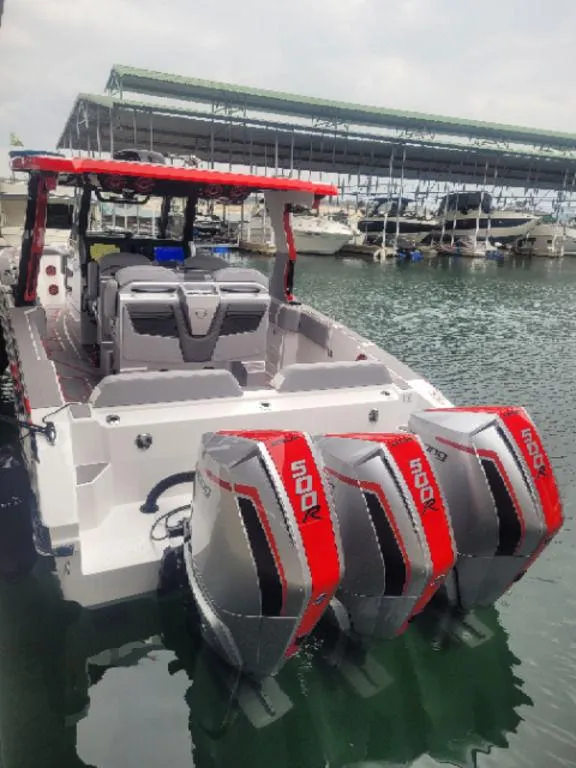 Slide: The Image of 2024 Fountain 38 SCX boat with triple 500 horsepower engines docked at a marina. - 27