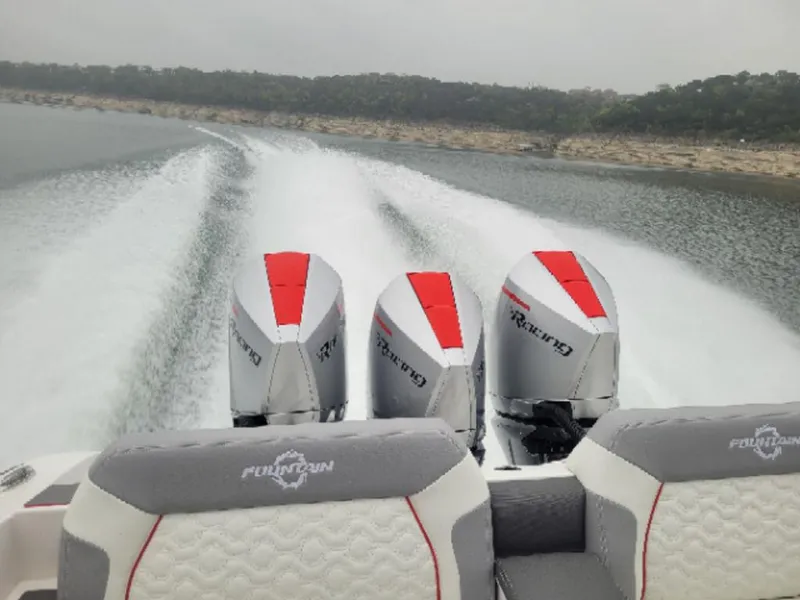 Slide: The Image of 2024 Fountain 38 SCX boat with triple engines cruising on a lake. - 28