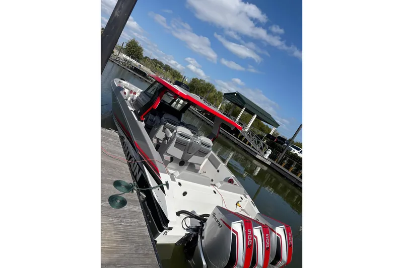 Slide: The Image of 2024 Fountain 38 SCX boat docked, featuring triple 500R engines and sleek design. - 30