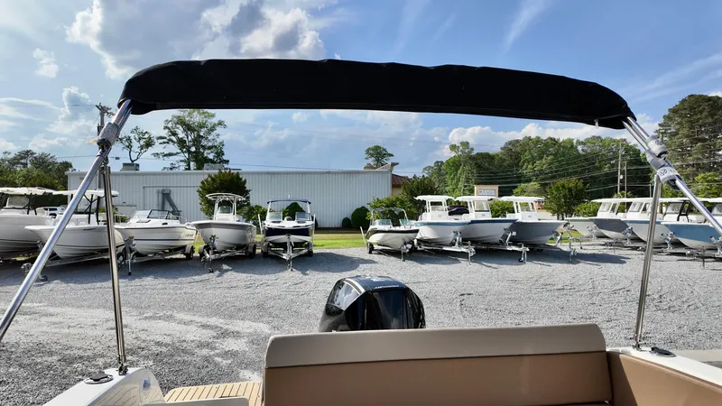 Slide: The Image of Bayliner TROPHY 25 EXPLORER 2025 at a boat dealership under a sunny sky. - 11