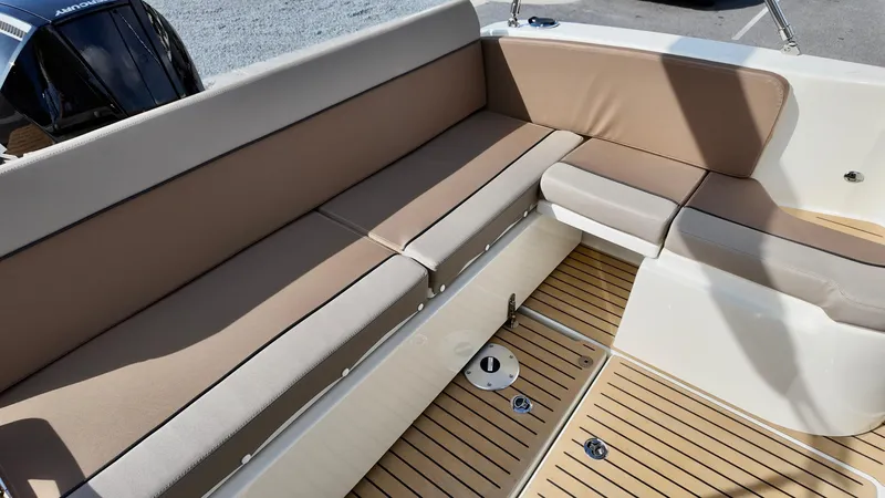 Slide: The Image of 2025 Bayliner TROPHY 25 EXPLORER boat interior with beige seating and wooden flooring. - 13
