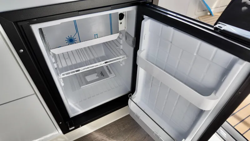 Slide: The Image of Open refrigerator inside 2025 Bayliner TROPHY 25 EXPLORER boat, showcasing interior storage space. - 18