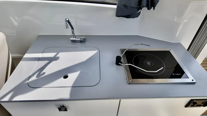 Slide: The Image of Compact kitchen area on 2025 Bayliner TROPHY 25 EXPLORER boat with sink and stove. - 21