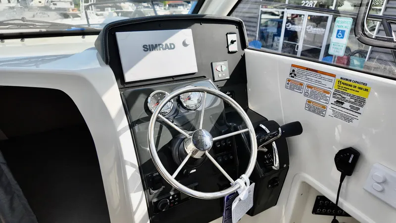 Slide: The Image of 2025 Bayliner TROPHY 25 EXPLORER helm with Simrad display and steering wheel. - 24