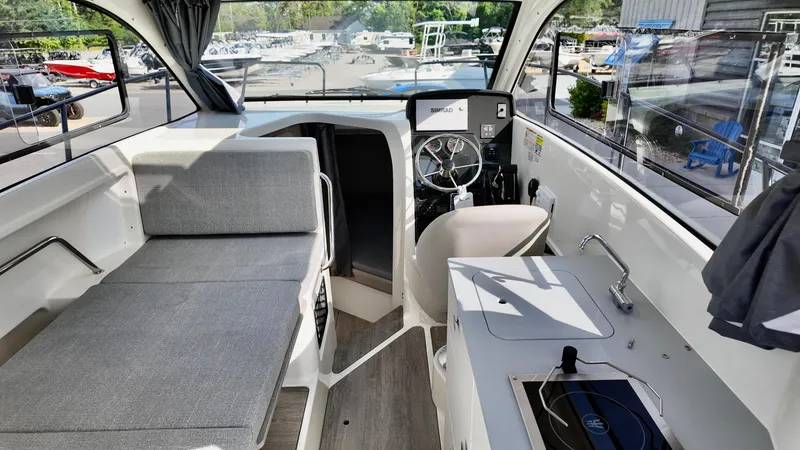 Slide: The Image of 2025 Bayliner TROPHY 25 EXPLORER interior with seating, helm, and kitchenette. - 25