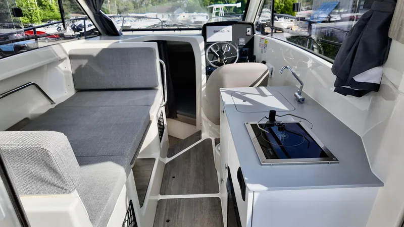 Slide: The Image of 2025 Bayliner TROPHY 25 EXPLORER interior with seating, steering, and kitchenette. - 26