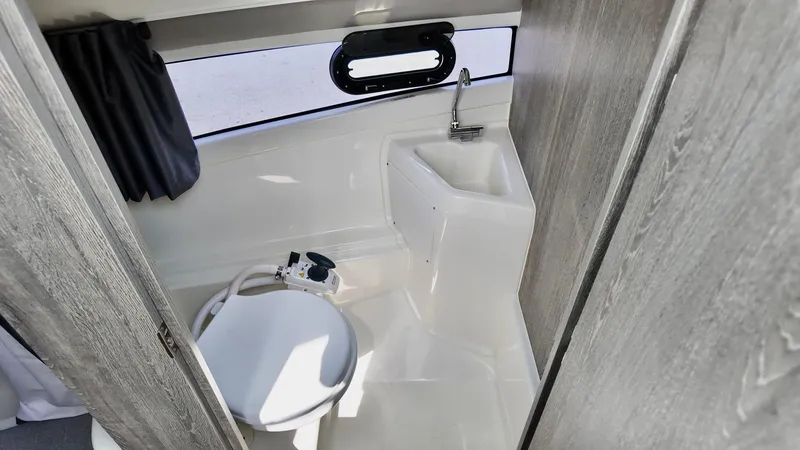 Slide: The Image of 2025 Bayliner TROPHY 25 EXPLORER boat bathroom with toilet and sink. - 27