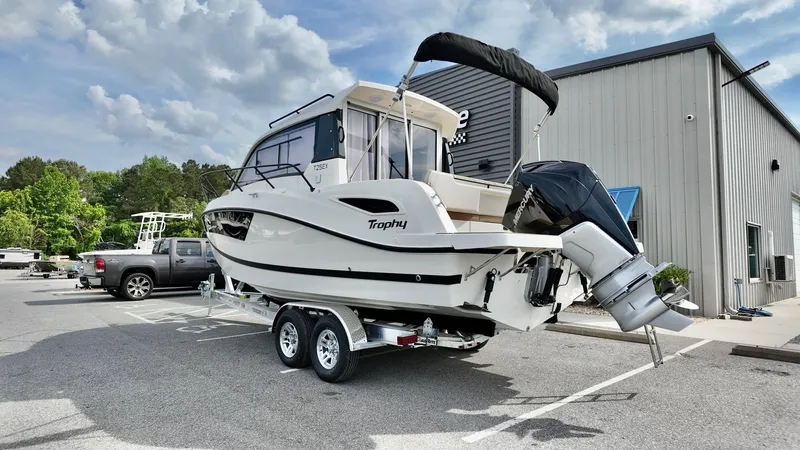 Slide: The Image of 2025 Bayliner TROPHY 25 EXPLORER boat on trailer, parked outdoors near a building. - 3