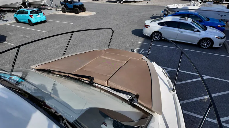 Slide: The Image of 2025 Bayliner TROPHY 25 EXPLORER boat parked in a lot with cars nearby. - 9