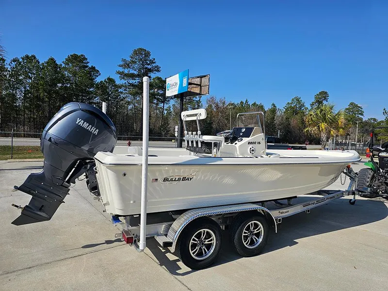 Slide: The Image of 2025 Bulls Bay 2200 XS boat on trailer with Yamaha outboard motor, parked outdoors. - 7
