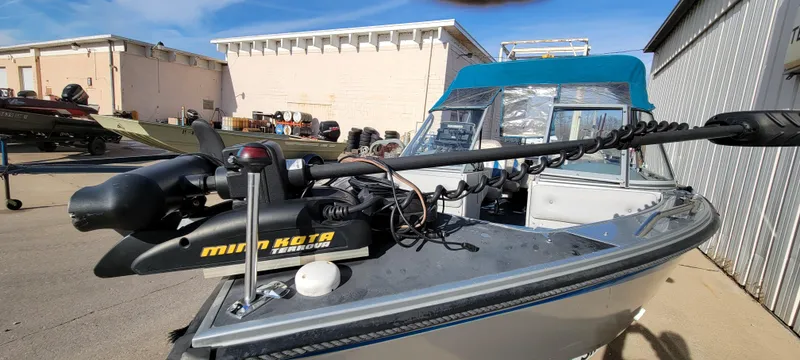 Slide: The Image of 1995 Crestliner Sportfish 1750 boat with Minn Kota trolling motor in a marina setting. - 11