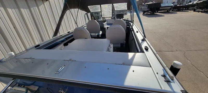 Slide: The Image of 1995 Crestliner Sportfish 1750 boat interior with seating and canopy, parked outdoors. - 3