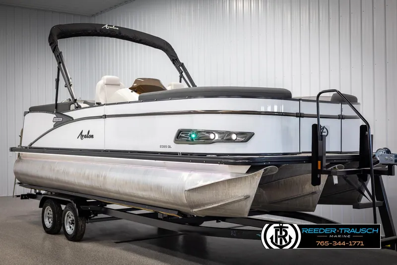 Slide: The Image of 2021 Avalon Catalina QL pontoon boat on trailer in indoor showroom. - 2