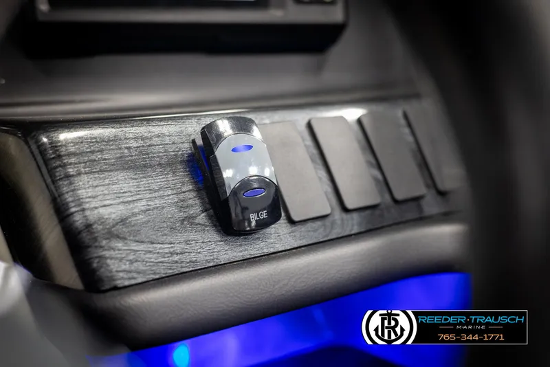 Slide: The Image of 2021 Avalon Catalina QL dashboard with illuminated bilge switch and blue ambient lighting. - 34